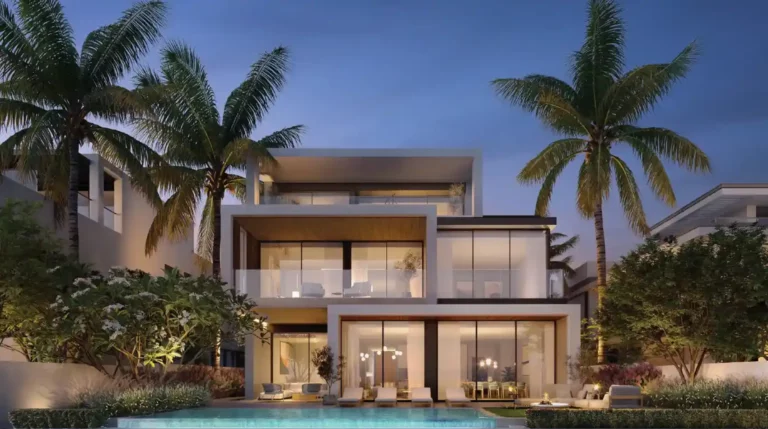Modernes zweistöckiges Haus mit großen Glasfenstern, beleuchteten Innenräumen und einem Swimmingpool davor, umgeben von Palmen und Grün in der Abenddämmerung.